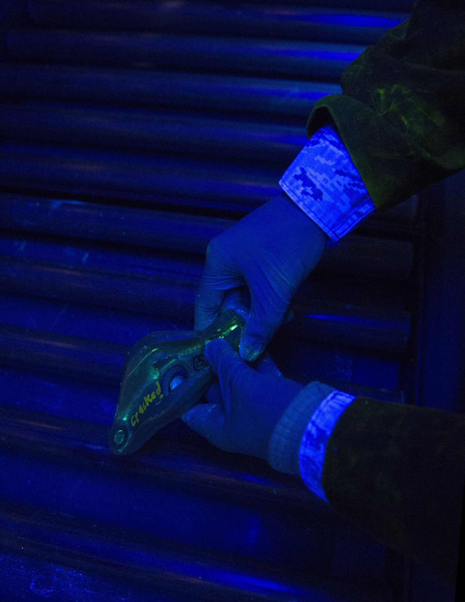 U.S. Air Force Staff Sgt. Gavriel Depringer-Gottfried, 133rd Maintenance Squadron, inspects the tow-fitting arm under a black light in St. Paul, Minn., Feb. 26, 2017.
