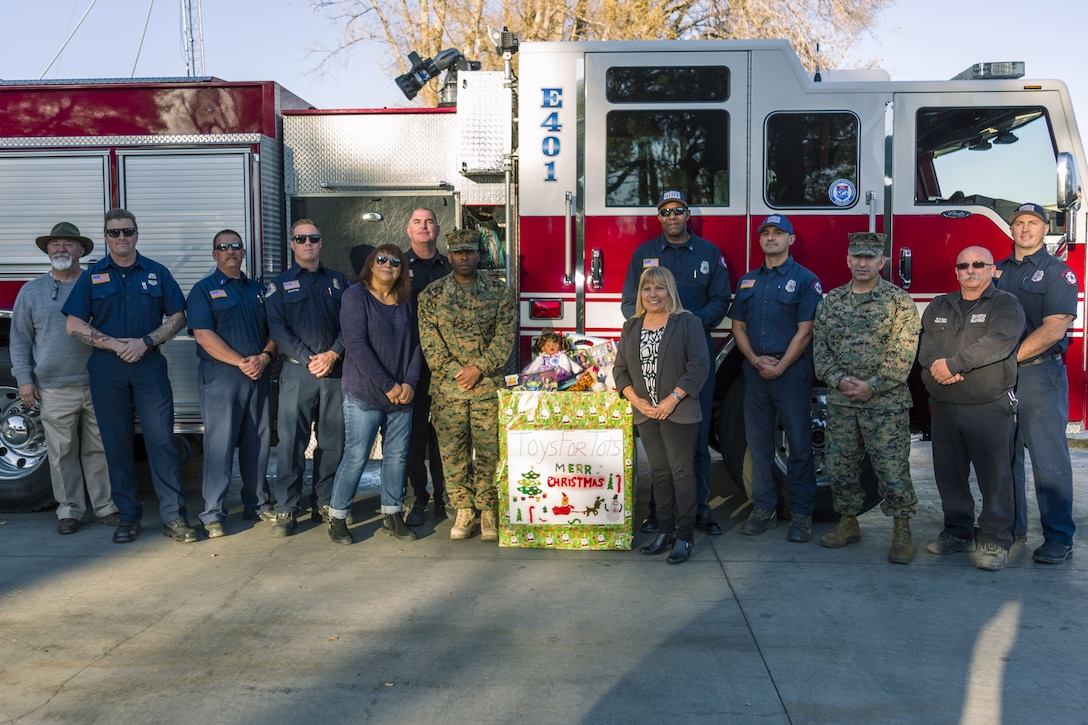 Col. Sekou Karega, commanding officer, Marine Corps Logistics Base Barstow, stands with Lucy Perez, president,  (left) and Emily Jenright ,vice president, of American Legion Ladies Auxiliary Leo Collins Unit 229, based in Adelanto, CA. On Dec. 19 members of the Ladies Auxiliary donated several boxes to the Toys for Tots campaign, which helps raise toys and funds in support of the local communities.