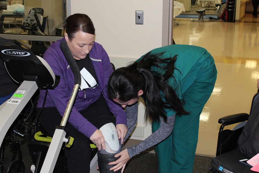 Physical Therapist Kyla Dunlavey, guides Maj. Stephanie Proelloch’s leg into her new prosthesis at Walter Reed National Military Medical Center, Nov. 15, 2017. Dunlavey has been a physical therapist for over 14 years and has worked with many amputee Service members. (U.S. Air Force photo by Karina Luis)