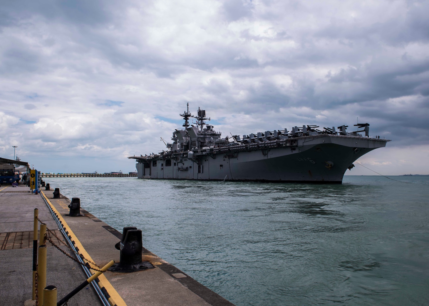 The amphibious assault ship USS America (LHA 6) pulls in to RSS Singapura - Changi Naval Base, Singapore during a regularly scheduled port visit Dec. 22. America, part of the America Amphibious Ready Group, with embarked 15th Marine Expeditionary Unit, is operating in the Indo-Asia Pacific region to strengthen partnerships and serve as a ready-response force for any type of contingency