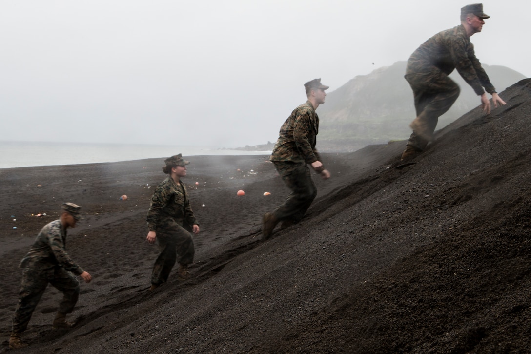 Marines with III Marine Expeditionary Force climb the steep slope of the landing beaches during a trip to Iwo Jima, Japan, Dec. 19, 2017. Marines from across III MEF, the 31st MEU and Marine Corps Installations Pacific, flew some 850 miles east, from Okinawa, Japan, to visit the historic island, now called Iwo To, to tour the battle site and honor the men who fought there in February 1945. (U.S. Marine Corps photo by Staff Sgt. T. T. Parish/Released)