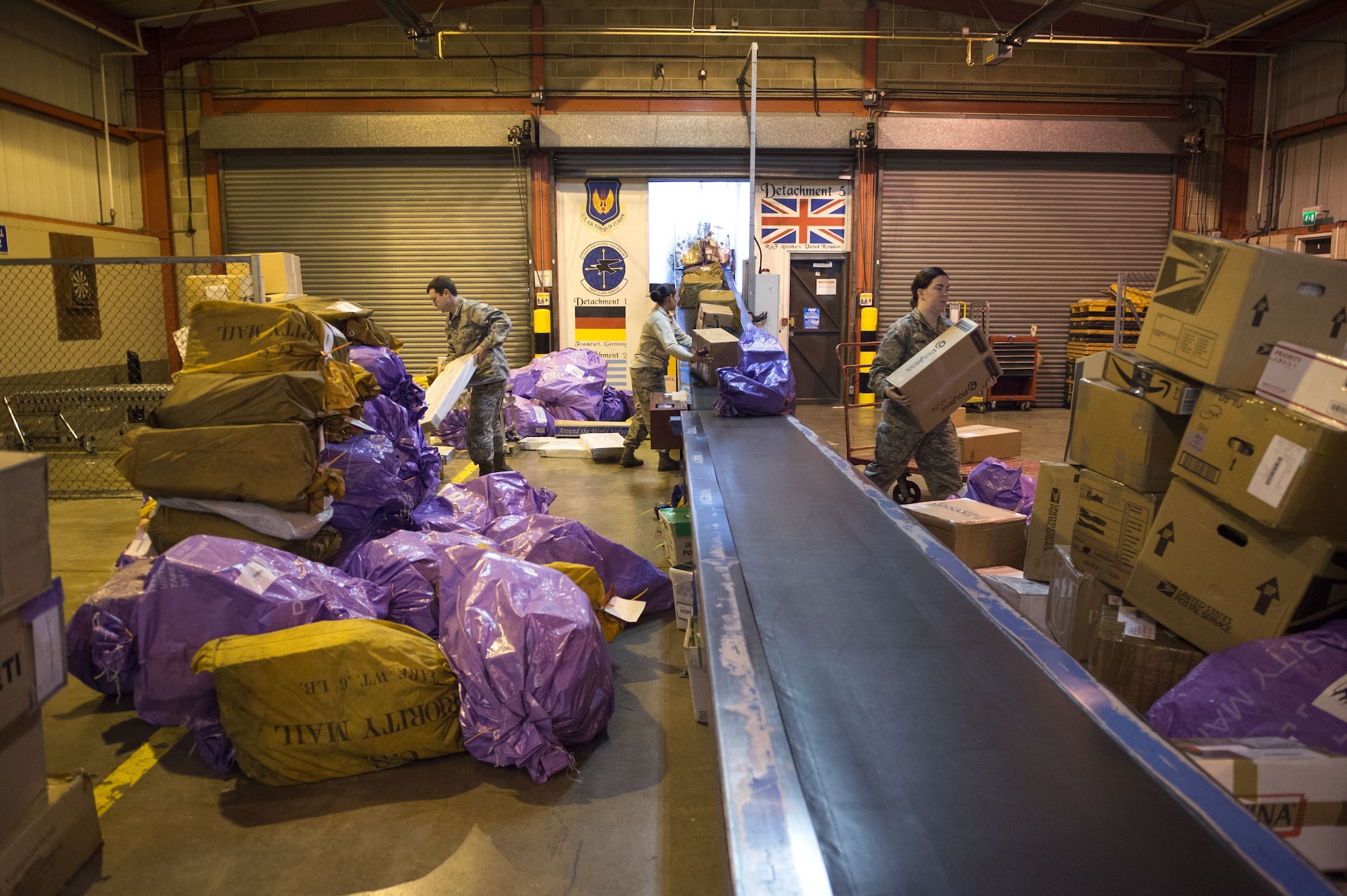 U.S. Air Force Airmen stack packages at RAF Alconbury, Dec. 19, 2017. The packages are loaded into trucks and taken to the seven different bases in the 501st Combat Support Wing. (U.S. Air Force photo by Airman 1st Class Chase Sousa)