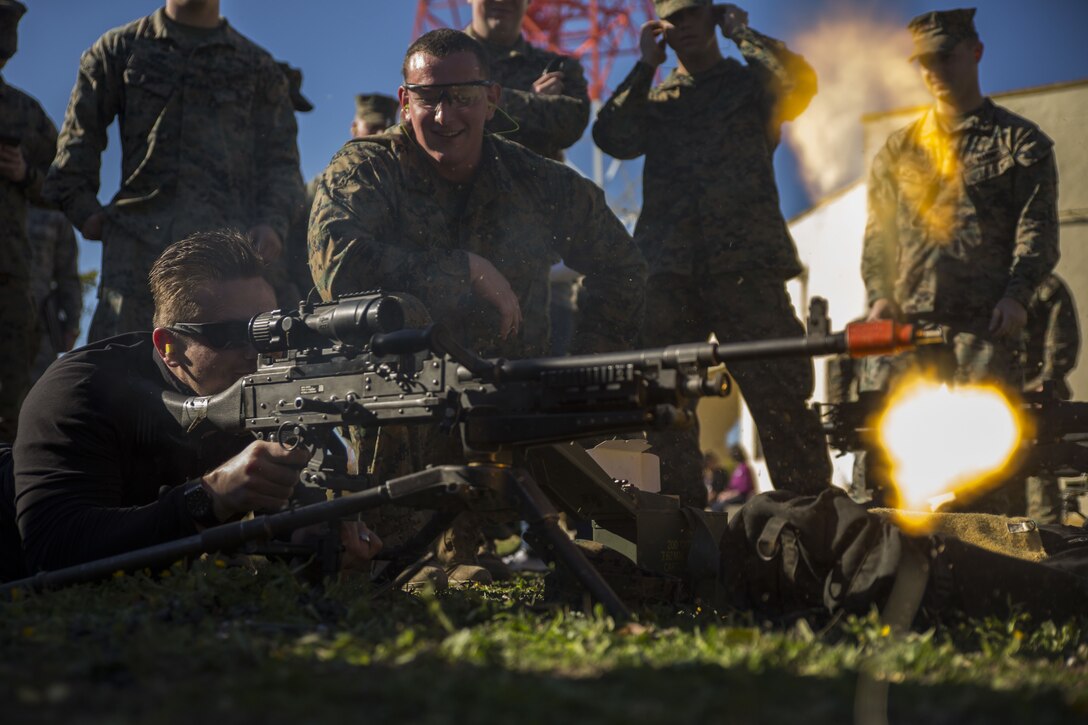 A U.S. Marine with Special Purpose Marine Air-Ground Task Force-Crisis Response-Africa teaches Michael Mizanin (The Miz) how to fire an M240 machine gun during a USO visit featuring Joint Chiefs of Staff and celebrities to Morón Air Base, Spain, Dec. 21, 2017. For more than 75 years, the USO has provided a vital connection between service members, their families and the American people. (U.S. Marine Corps photo by Sgt. Takoune H. Norasingh/Released)