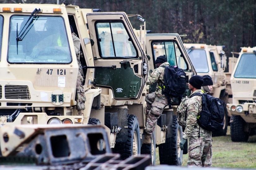 Soldiers with the 47th Transportation Company prepare to move their trucks from the staging area to the motor pool in Powidz, Poland.