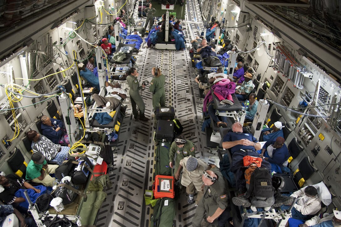 Reserve Citizen Airmen assigned to the 45th Aeromedical Evacuation Squadron, assist patients while aboard a C-17 Globemaster III in St. Croix, U.S. Virgin Islands, Sept. 24, 2017. Within hours after Hurricane Maria impacted the U.S. Virgin Islands, Reserve Citizen Airmen, from MacDill Air Force Base, Florida, were tasked to conduct humanitarian missions. (U.S. Air Force photo by Tech. Sgt. Peter Dean)