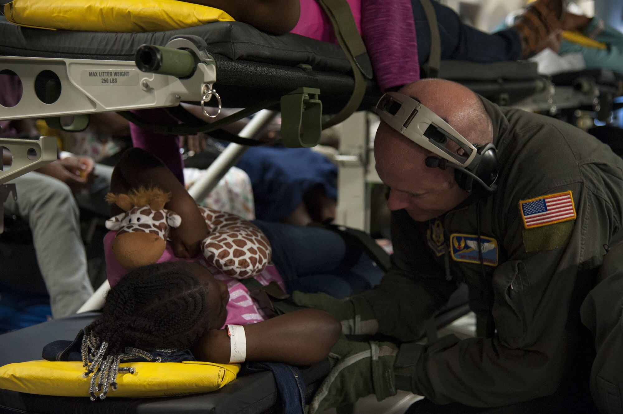 U.S. Air Force Tech. Sgt. Frank Balisciano, assigned to the 45th Aeromedical Evacuation Squadron, interacts and comforts a young patient aboard a C-17 Globemaster III while enroute from St. Croix to Dobbins Air Reserve Base, Ga., Sept. 24, 2017. Reserve Citizen Airmen established operations at MacDill AFB Fla. to support humanitarian relief efforts for islands affected by Hurricane Maria. (U.S. Air Force photo by Tech. Sgt. Peter Dean)