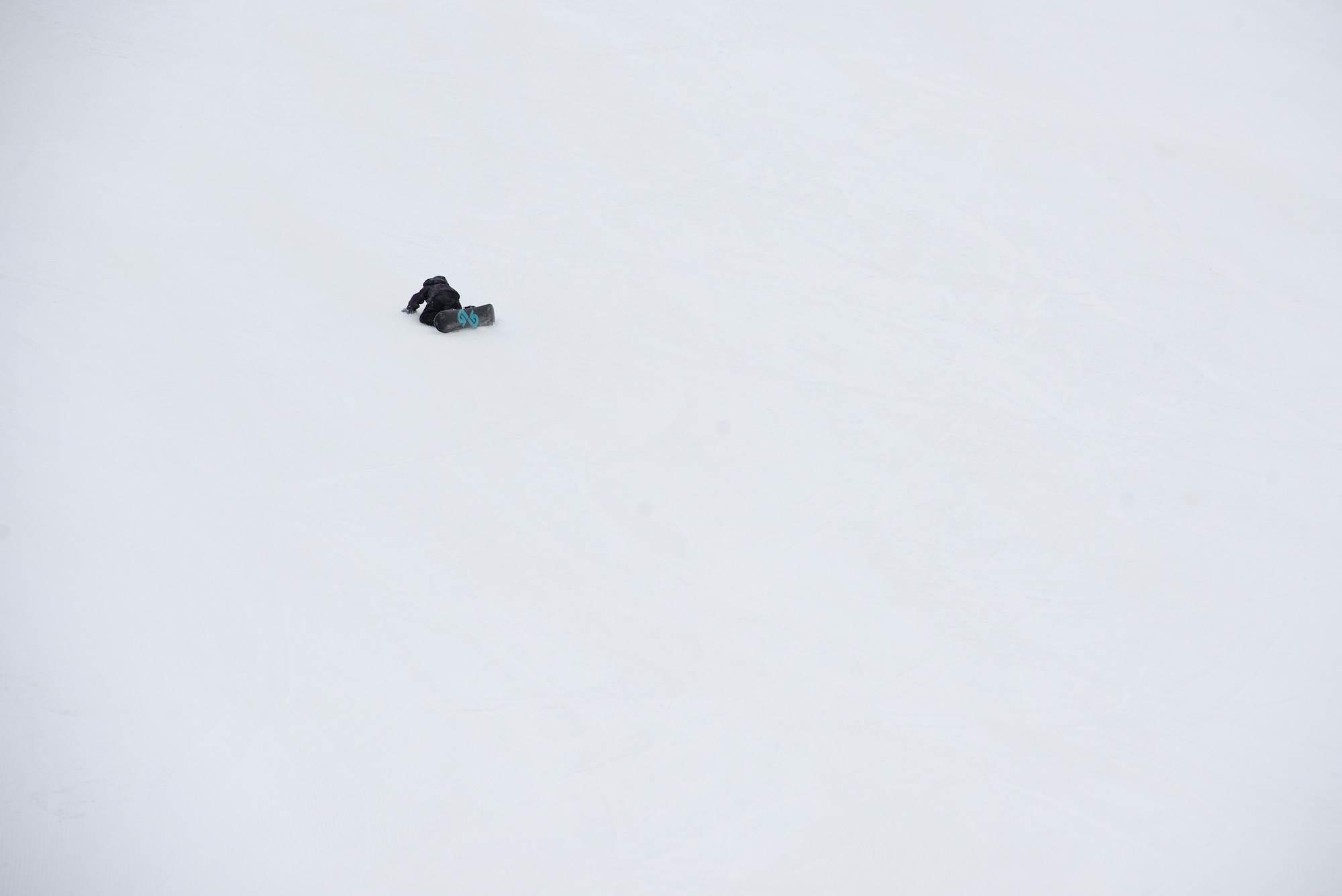 A snowboarder lies in the snow at the Hillberg Ski Area during Winterfest at Joint Base Elmendorf-Richardson, Alaska, Dec. 21, 2017. Winterfest was a winter solstice celebration hosted by Hillberg for anyone with base access and offered a plethora of events from noon to as late at 8 p.m.