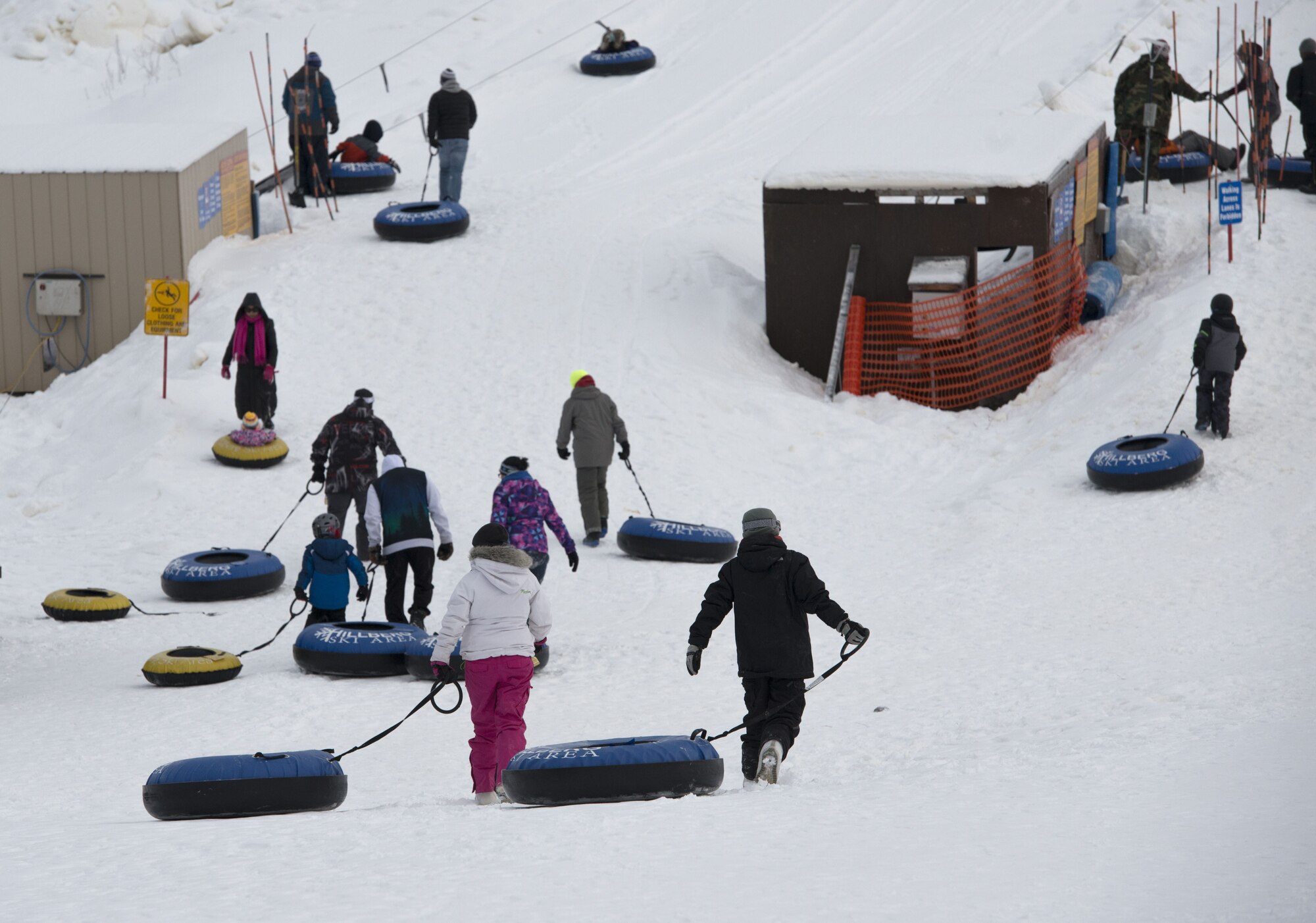 Children and parents walk to the tube lift at the Hillberg Ski Area during Winterfest at Joint Base Elmendorf-Richardson, Alaska, Dec. 21, 2017. Winterfest was a winter solstice celebration hosted by Hillberg for anyone with base access and offered a plethora of events from noon to as late at 8 p.m.