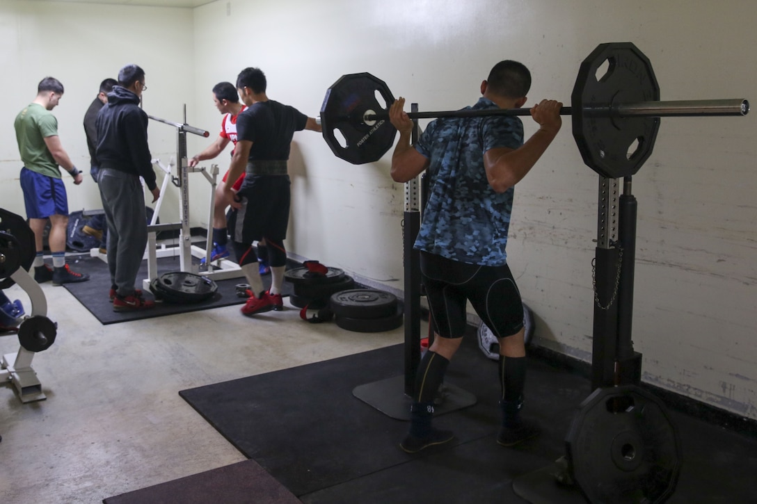 Athletes warm up in the weight room during the Foster Powerlifting Competition Dec. 17 at the Community Center aboard Camp Foster, Okinawa, Japan. Certified Okinawa powerlifting officials ensured the competition was up to the International Powerlifting Federation standards. Athletes from the local and military communities participated in squat, bench press and deadlift events during the competition. (U.S. Marine Corps photo by Pvt. Nicole Rogge)