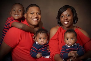 A man, woman and three children pose for a family photo.