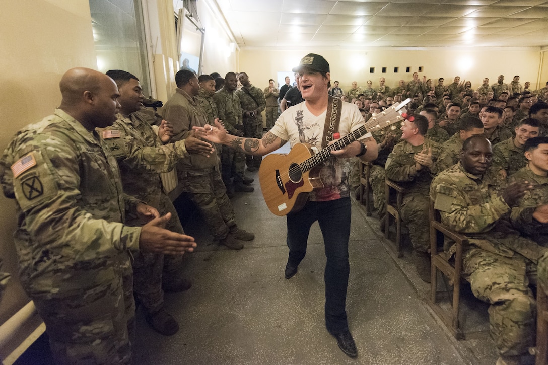 A musician high fives military personnel.