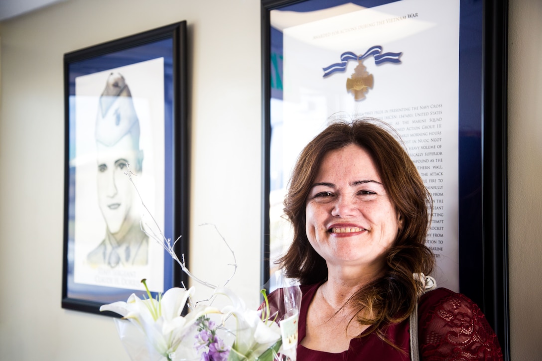 Chikako McMasters, a Vietnam war hero’s daughter, stands in front of a portrait and biography of her father that are located at the entrance of Dorris Hall