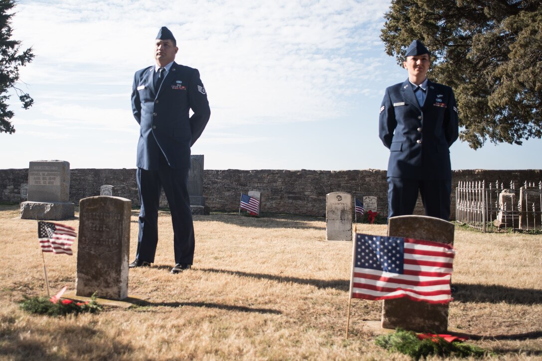 Members of the Will Rogers Air National Guard Junior Enlisted Council, Staff Sgt. David Carrillo and Airman 1st Class Brooke Evans, observe a moment of silence after laying wreaths on the graves of fallen service members at the annual Patriot Wreath Ceremony at Historic Fort Reno in El Reno, Okla., Dec. 16, 2017. (U.S. Air National Guard Photo by Senior Airman Caitlin Carnes/Released)