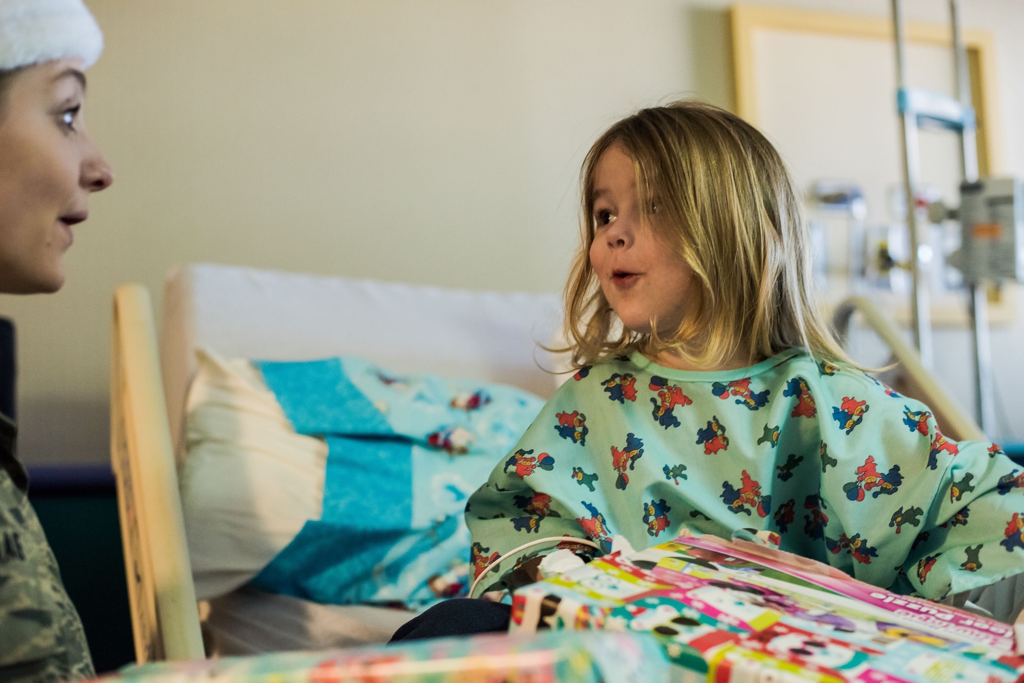Staff Sgt. Jaimie Haase, treasurer for the Junior Enlisted Council at Will Rogers Air National Guard Base, Okla., visits with Isla Schulz while delivering gifts to children at INTEGRIS Baptist Health Center, Oklahoma City, Dec. 15, 2017. The JEC collected toys in the months leading up to December and distributed them to families who would be at the hospital over the holidays. (U.S. Air National Guard photo by Senior Airman Brigette Waltermire/Released)