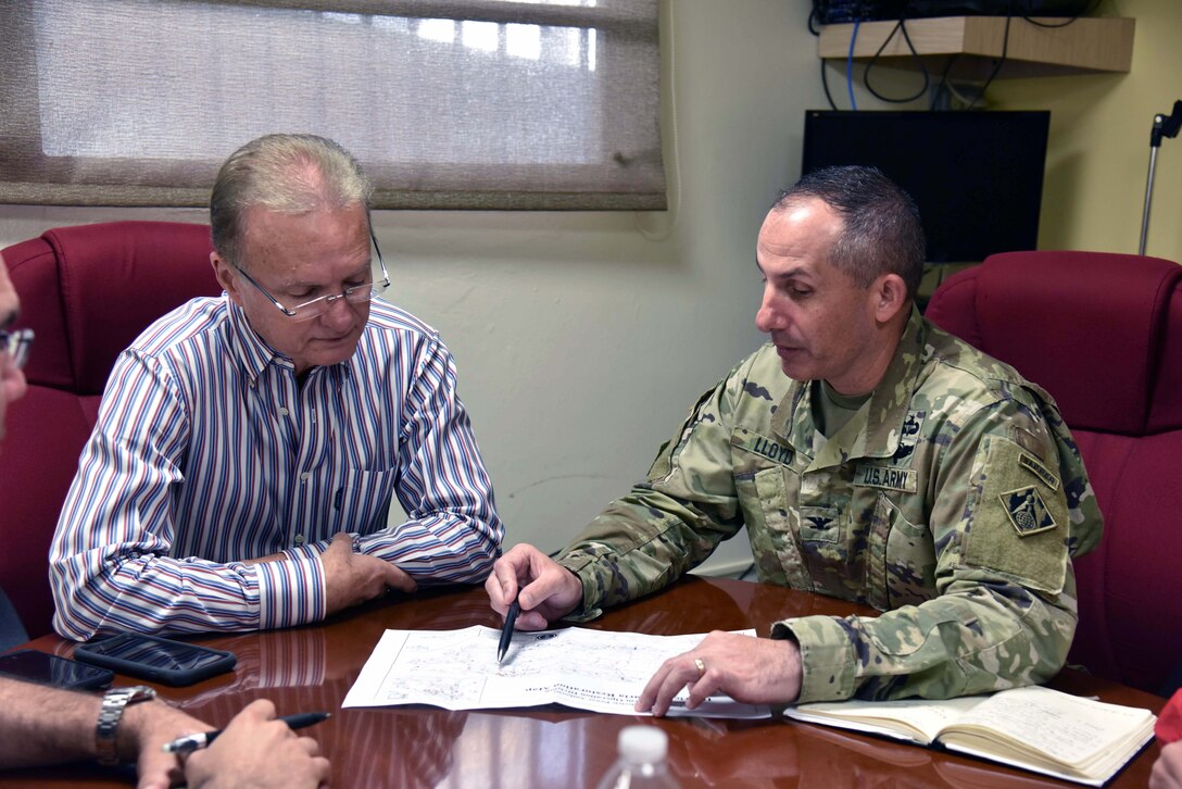 Bayamon Mayor  Ramon L. Rivera Cruz and U.S. Army Corps of Engineers Task Force Power Restoration Commander Col. John Lloyd discuss the progress of the power grid restoration while meeting at the city administration building in Bayamon, Puerto Rico, Dec. 22. The task force sought the use of city property for the storage of critical materials used in the power restoration mission, including utility poles and other power grid supplies. The city is allowing the Corps use of its property and infrastructure to help expedite delivery of needed power grid supplies and equipment across the island.