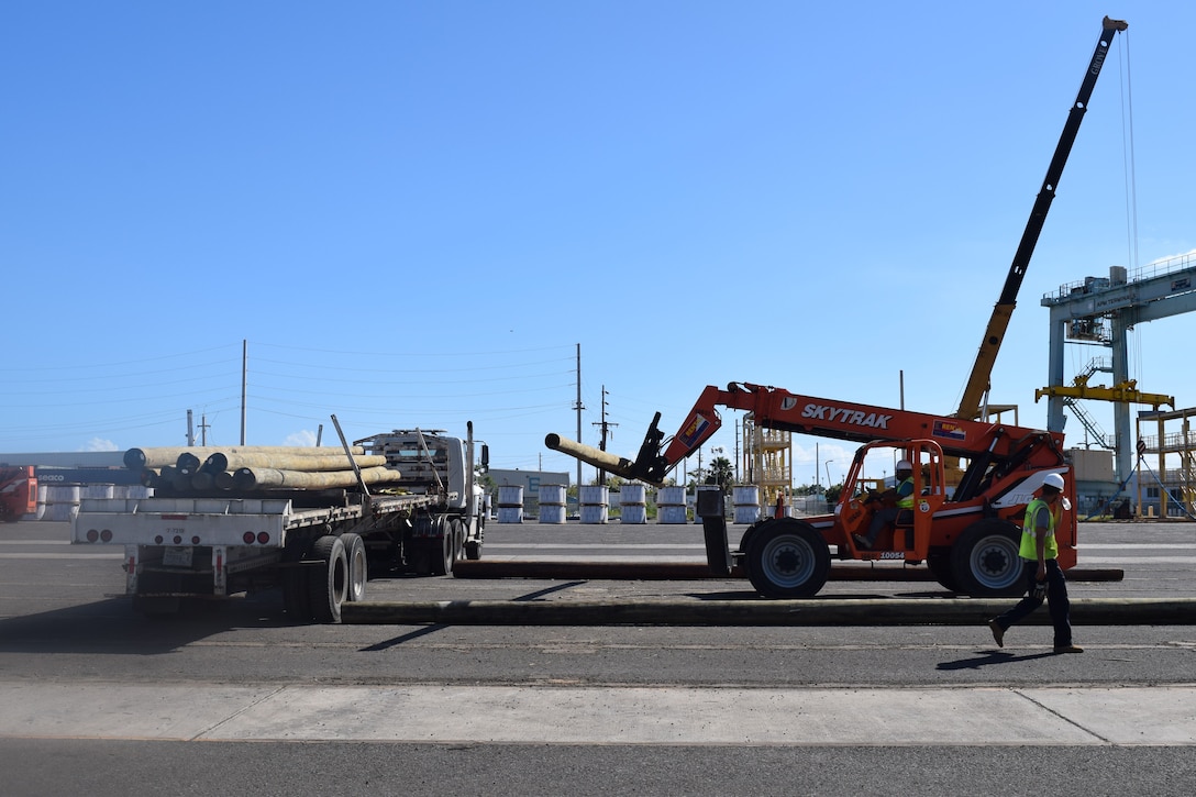 Pressure-treated wooden utility poles are unloaded at the lay-down yard in Ponce, Puerto Rico, part of the tons of critical electrical components flowing in daily from throughout the nation to rebuild the island’s electrical distribution system. The U.S. Army Corps of Engineers’ Task Force Power Restoration team, works 12-hour shifts, seven days a week, to complete the mission of rebuilding Puerto Rico’s devastated power grid.