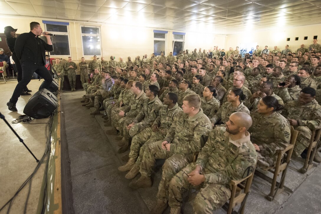 Celebrities perform on stage for service members.