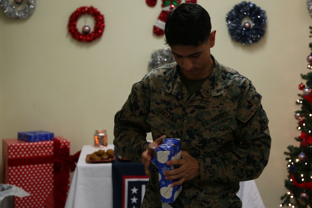 CAMP FOSTER, OKINAWA, Japan – Lance Cpl. Matthew Santana opens his raffle gift Dec. 28 during the USO Holiday Dinner aboard Camp Foster, Okinawa, Japan.