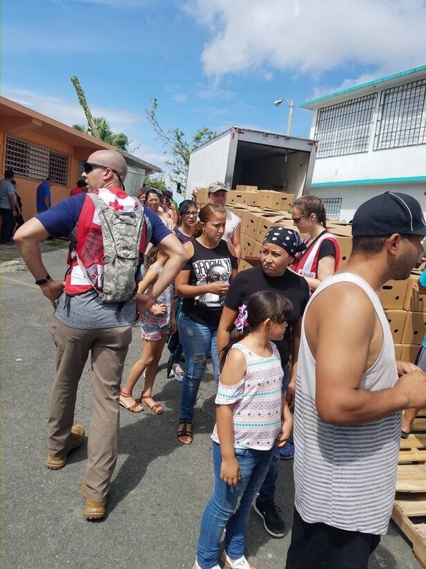 Army Sgt. 1st Class Rafael Ortiz, left, a cybersecurity noncommissioned officer with the 781st Military Intelligence Battalion and a Red Cross team leader, works with a member of his team to provide assistance items to local residents in Ortiz’s hometown during a humanitarian mission in Naranjito, Puerto Rico, Oct. 15, 2017. Courtesy photo