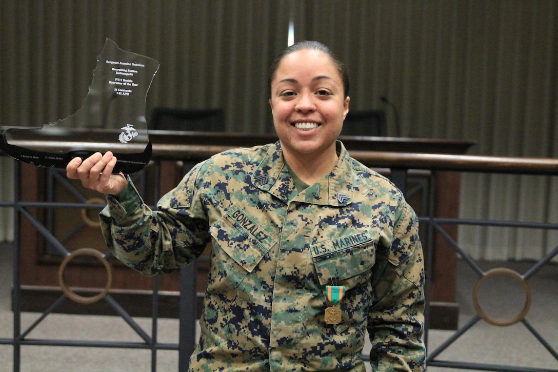 Sgt Jasmine Gonzalez holds her Rookie Recruiter of the Year trophy while wearing her Navy and Marine Corps Achievement Medal. Sgt Gonzalez was the fiscal year 2017 Rookie Recruiter of the Year for Recruiting Station Indianapolis.
