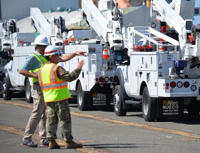 electrical workers talk near vehicles