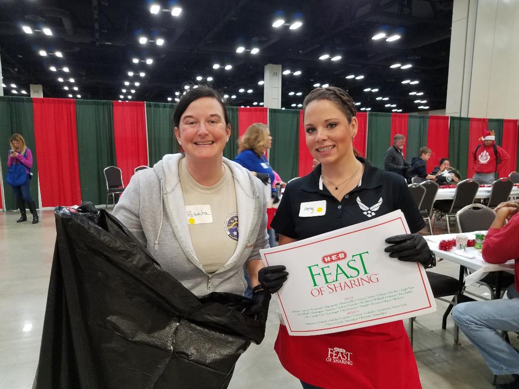 Senior Airman Leslie Ybarra, 433 Aerospace Medicine,  Squadron, medical technician carries a tray of plates to guests at the H-E-B’s 25th Annual Feast of Sharing on Dec. 23, 2017, at the Henry B. Gonzalez Convention Center in San Antonio, Texas. Ybarra was among 40 Alamo Wing members, friends and family, who helped the afternoon shift of volunteers serve up dinners at the Henry B. Gonzalez Convention Center in San Antonio, Texas. (U.S. Air Force photo by Tech. Sgt. Carlos J. Treviño)