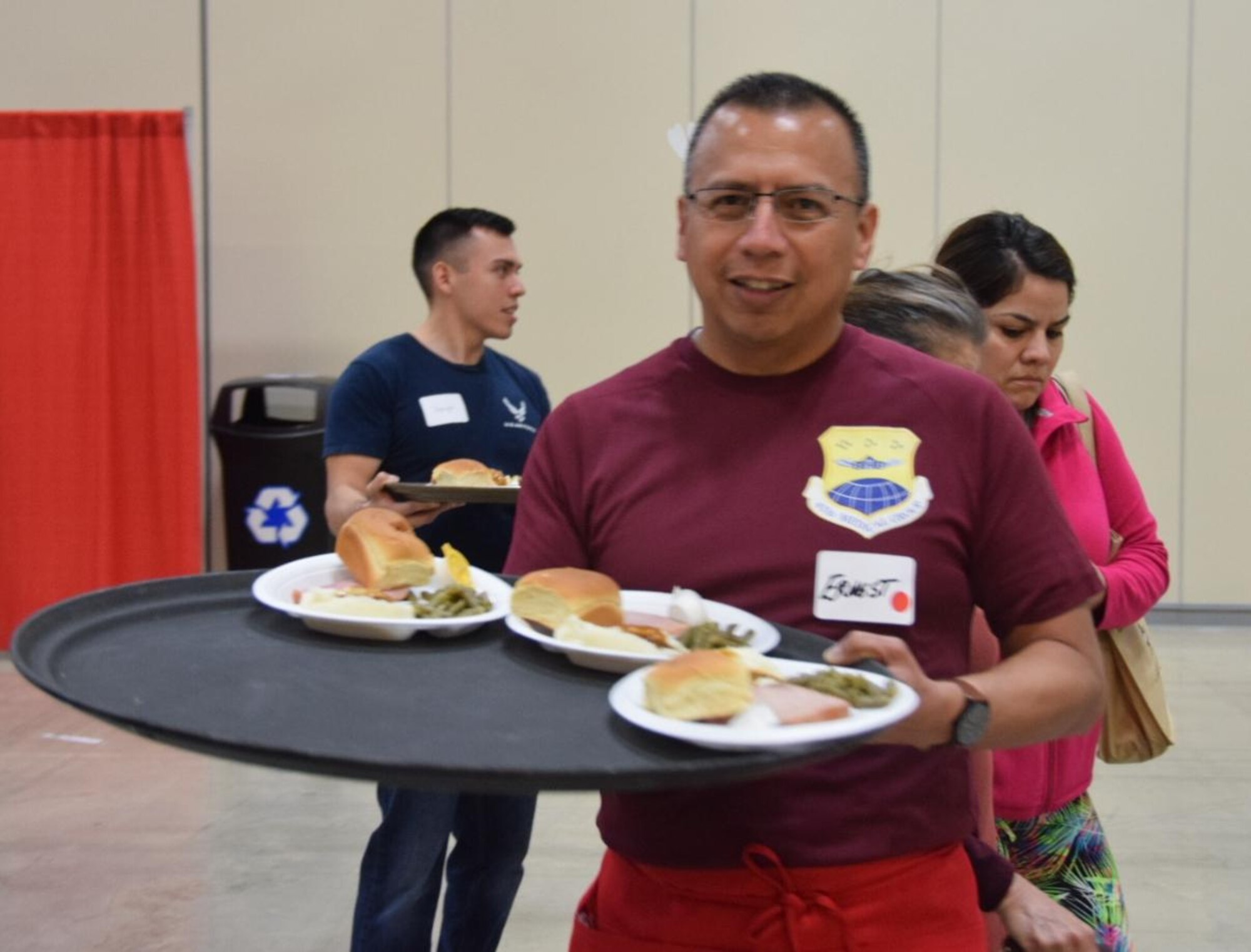 Senior Airman Leslie Ybarra, 433 Aerospace Medicine,  Squadron, medical technician carries a tray of plates to guests at the H-E-B’s 25th Annual Feast of Sharing on Dec. 23, 2017, at the Henry B. Gonzalez Convention Center in San Antonio, Texas. Ybarra was among 40 Alamo Wing members, friends and family, who helped the afternoon shift of volunteers serve up dinners at the Henry B. Gonzalez Convention Center in San Antonio, Texas. (U.S. Air Force photo by Tech. Sgt. Carlos J. Treviño)