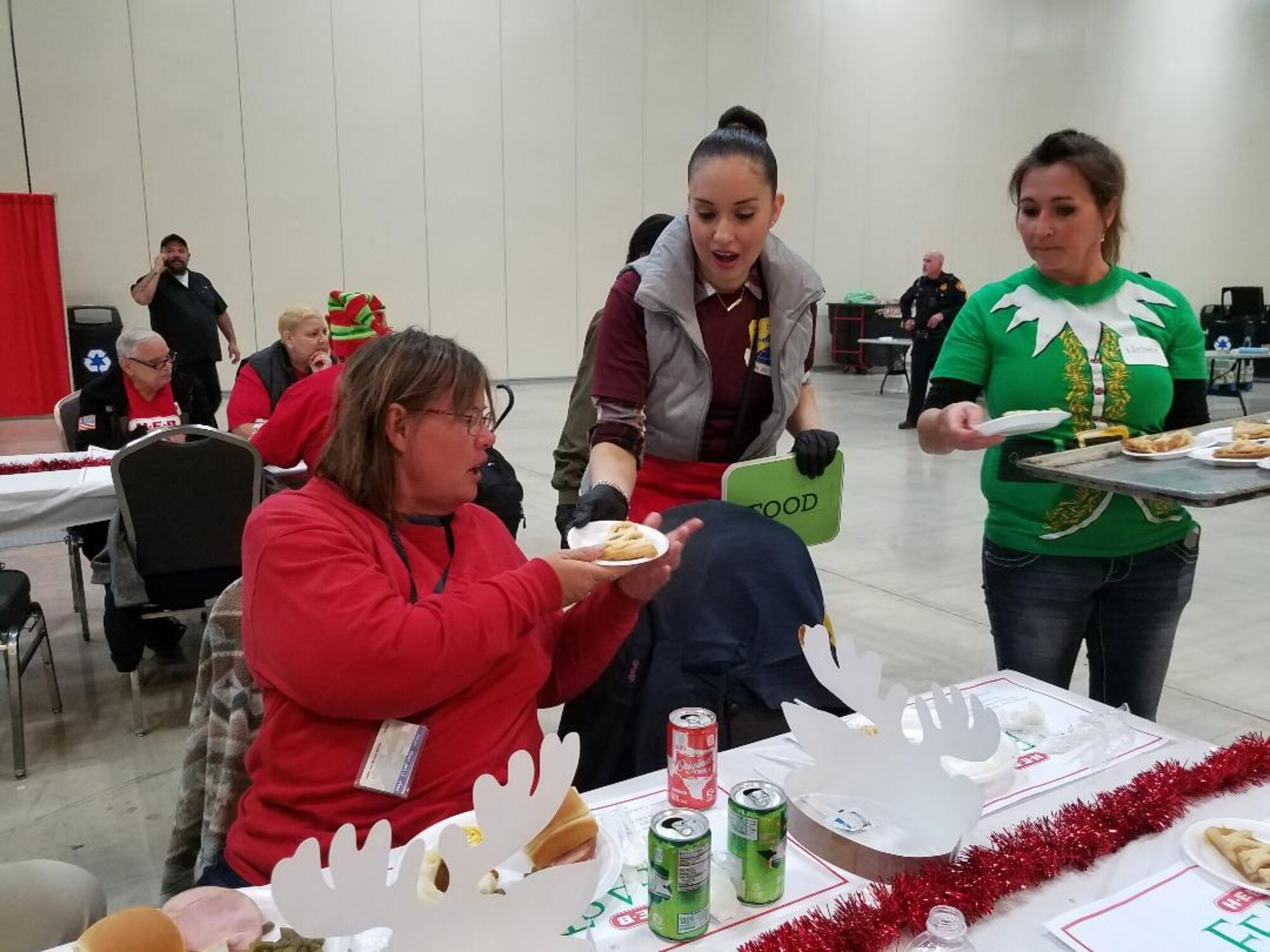 Senior Airman Leslie Ybarra, 433 Aerospace Medicine,  Squadron, medical technician carries a tray of plates to guests at the H-E-B’s 25th Annual Feast of Sharing on Dec. 23, 2017, at the Henry B. Gonzalez Convention Center in San Antonio, Texas. Ybarra was among 40 Alamo Wing members, friends and family, who helped the afternoon shift of volunteers serve up dinners at the Henry B. Gonzalez Convention Center in San Antonio, Texas. (U.S. Air Force photo by Tech. Sgt. Carlos J. Treviño)