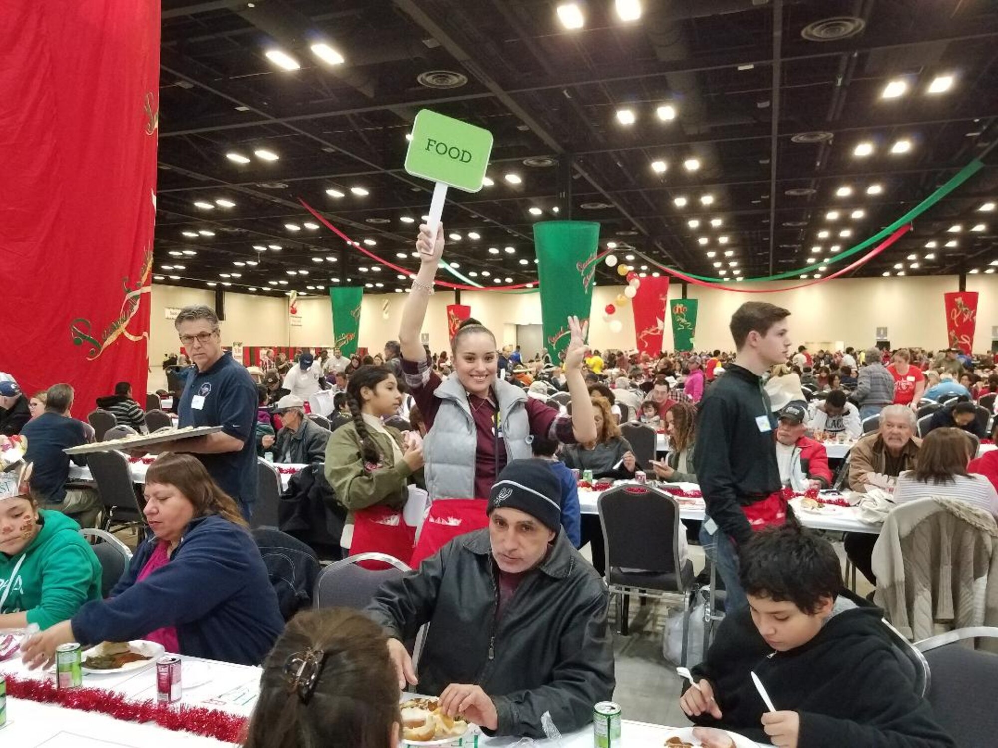 Senior Airman Leslie Ybarra, 433 Aerospace Medicine,  Squadron, medical technician carries a tray of plates to guests at the H-E-B’s 25th Annual Feast of Sharing on Dec. 23, 2017, at the Henry B. Gonzalez Convention Center in San Antonio, Texas. Ybarra was among 40 Alamo Wing members, friends and family, who helped the afternoon shift of volunteers serve up dinners at the Henry B. Gonzalez Convention Center in San Antonio, Texas. (U.S. Air Force photo by Tech. Sgt. Carlos J. Treviño)