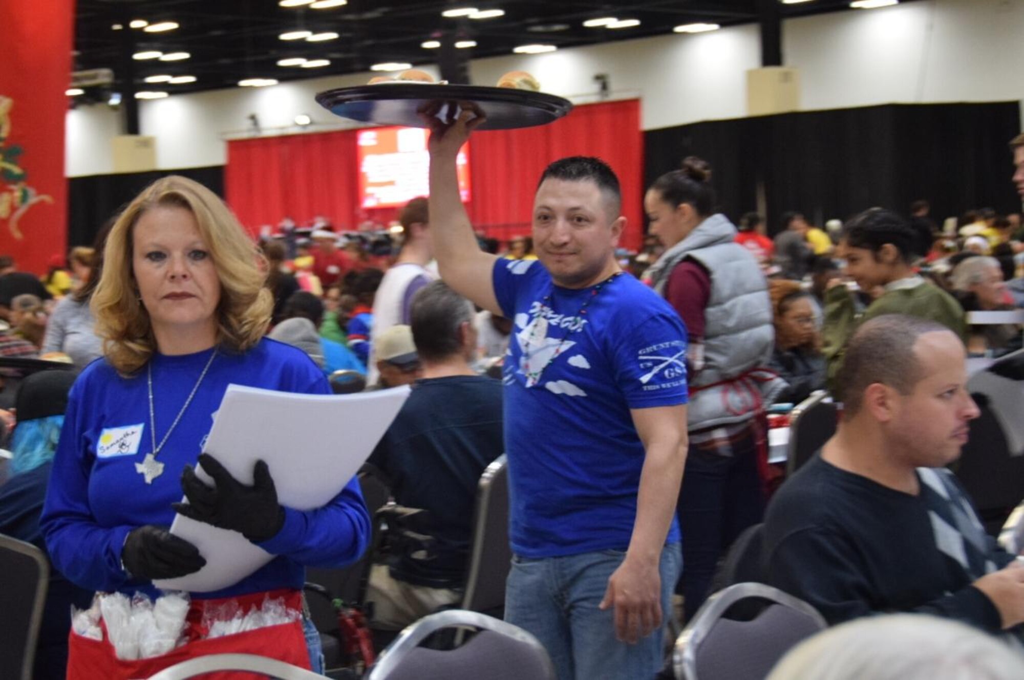 Senior Airman Leslie Ybarra, 433 Aerospace Medicine,  Squadron, medical technician carries a tray of plates to guests at the H-E-B’s 25th Annual Feast of Sharing on Dec. 23, 2017, at the Henry B. Gonzalez Convention Center in San Antonio, Texas. Ybarra was among 40 Alamo Wing members, friends and family, who helped the afternoon shift of volunteers serve up dinners at the Henry B. Gonzalez Convention Center in San Antonio, Texas. (U.S. Air Force photo by Tech. Sgt. Carlos J. Treviño)