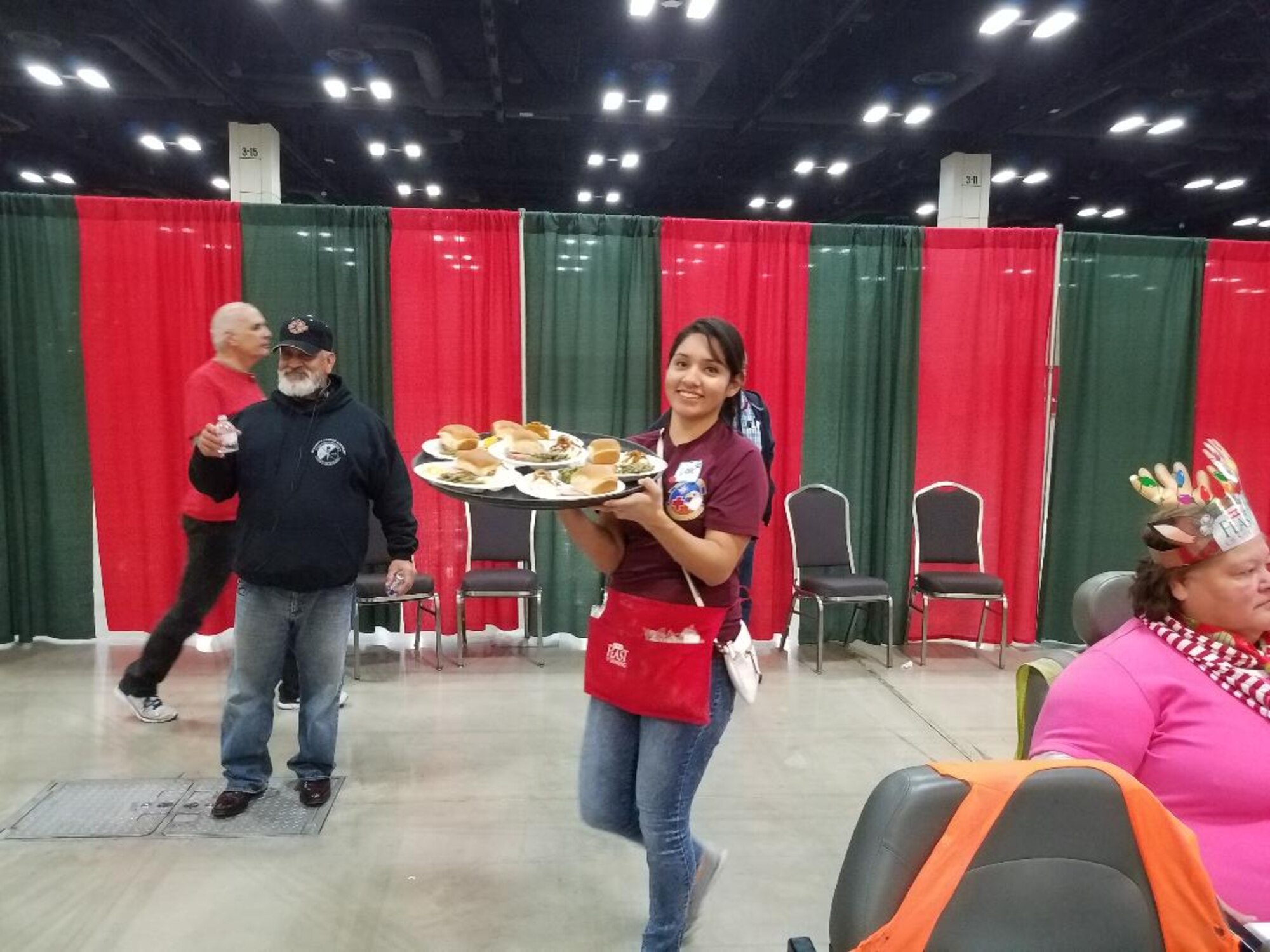Senior Airman Leslie Ybarra, 433 Aerospace Medicine,  Squadron, medical technician carries a tray of plates to guests at the H-E-B’s 25th Annual Feast of Sharing on Dec. 23, 2017, at the Henry B. Gonzalez Convention Center in San Antonio, Texas. Ybarra was among 40 Alamo Wing members, friends and family, who helped the afternoon shift of volunteers serve up dinners at the Henry B. Gonzalez Convention Center in San Antonio, Texas. (U.S. Air Force photo by Tech. Sgt. Carlos J. Treviño)