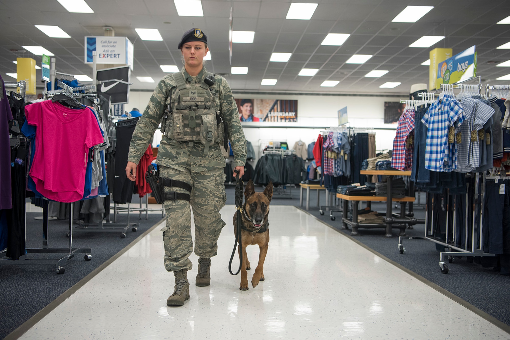 Staff Sgt. Chelsea Boe, 21st Security Forces Squadron military working dog handler, and her dog Gina are performing a walk-through of the base exchange at Peterson Air Force Base, Colorado, on Dec. 22, 2017. Part of a military wokrign dog handlers daily duties is random walk-throughs of areas around base. (U.S. Air Force photo by Steve Kotecki)