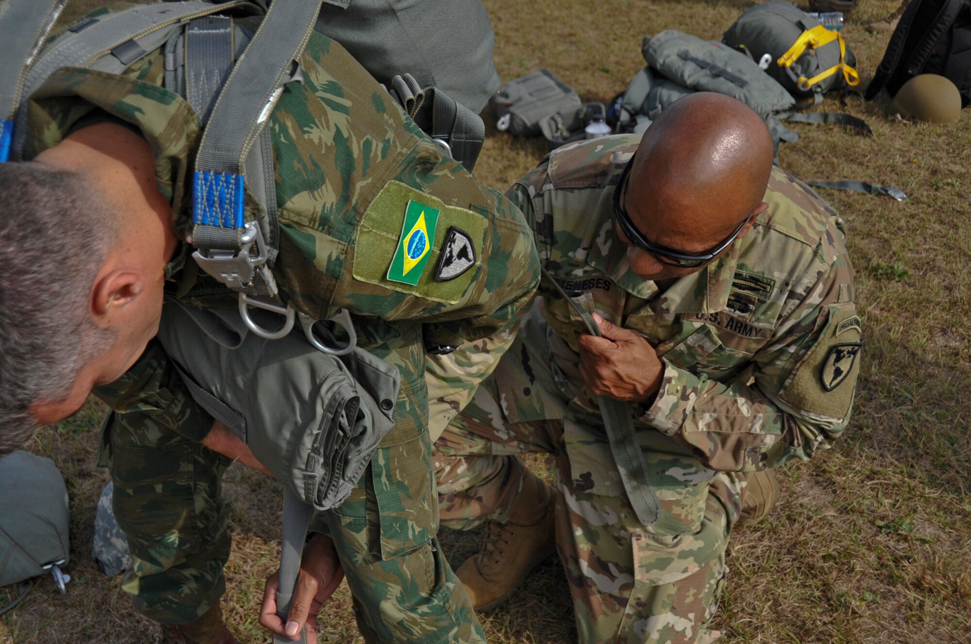 A Jumpmaster with 7th Special Forces Group (Airborne) performs jumpmaster inspection on a Brazilian paratrooper during "Operation Toy Drop" yielding over 300 toys for the affected families of Hurricane Maria in Puerto Rico.