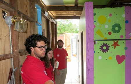 people look at damaged house