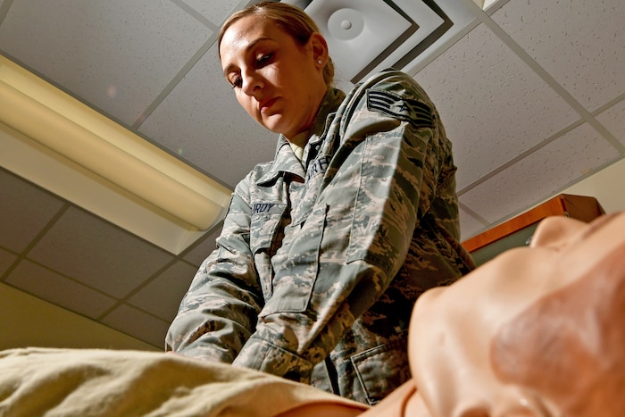 An Airman provides cardiopulmonary resuscitation to a training manikin.