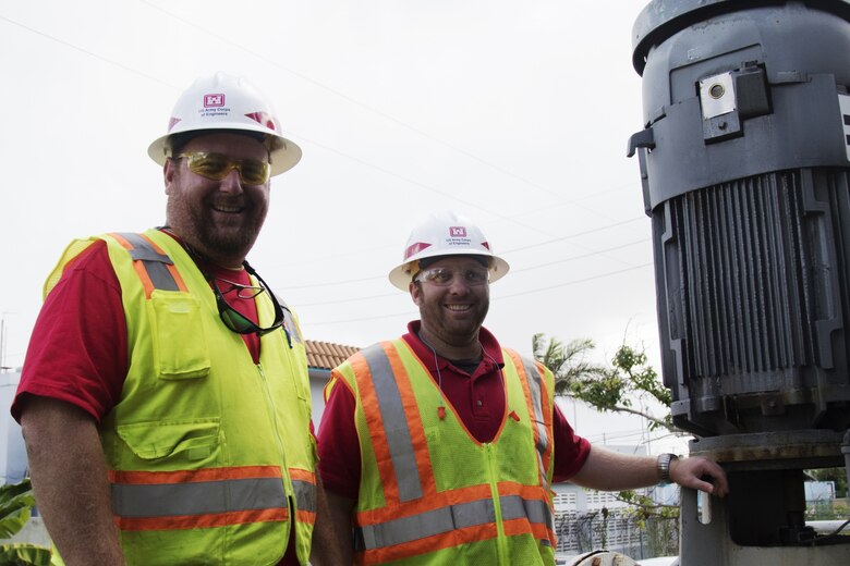 two men stand by a generator