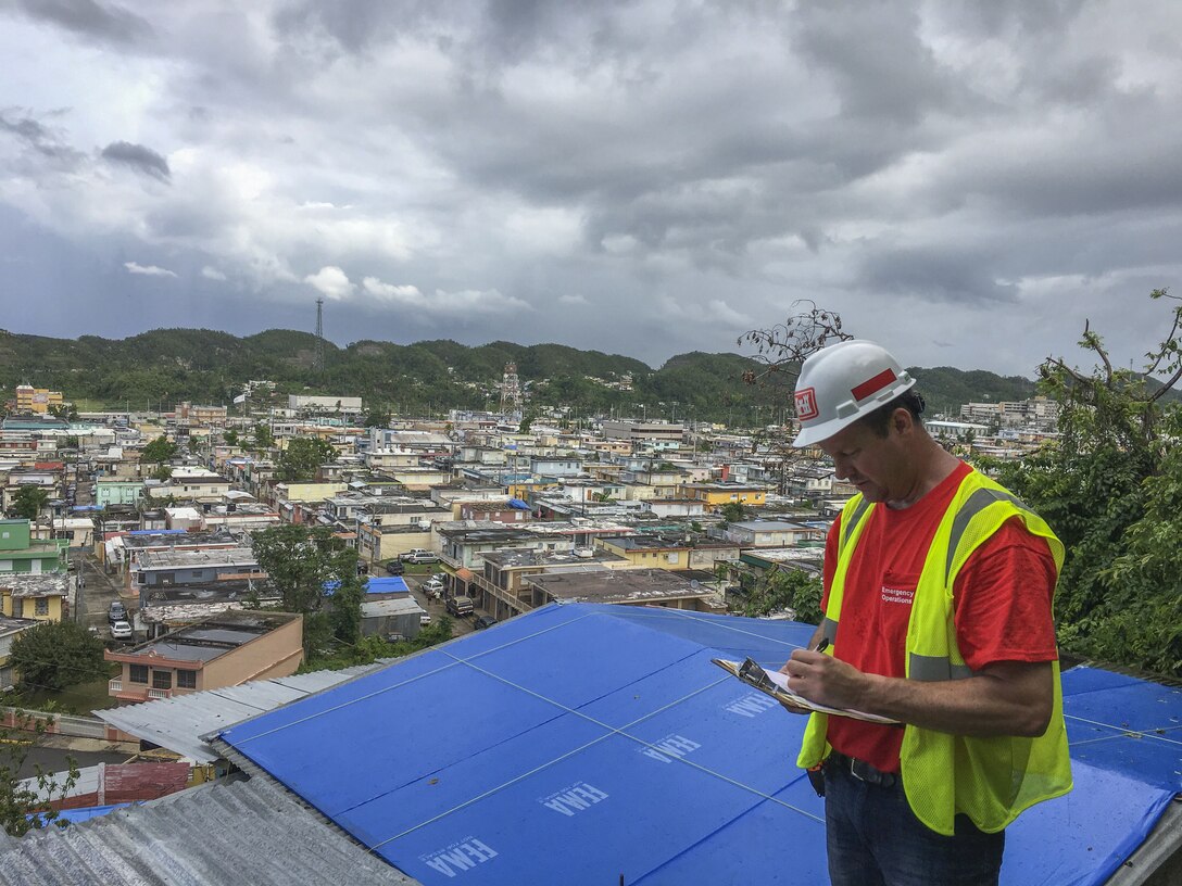 man inspects blue roof installation