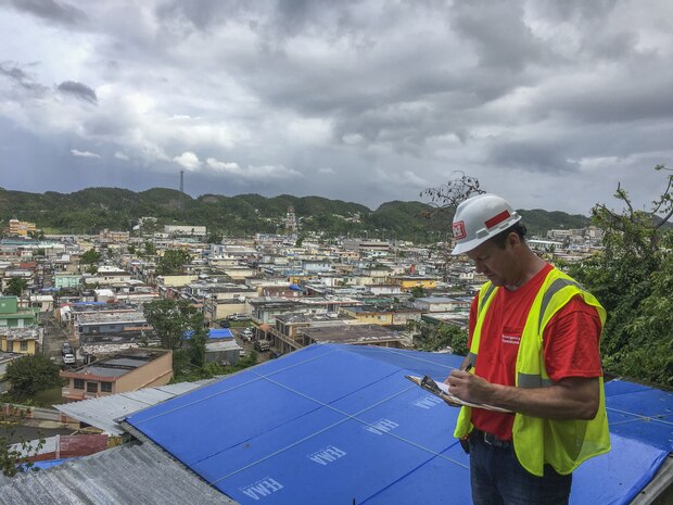 man inspects blue roof installation