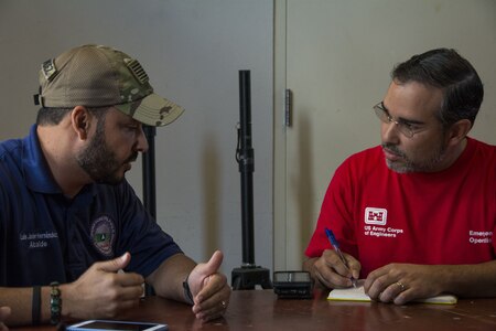 men discuss blue roof installations at table