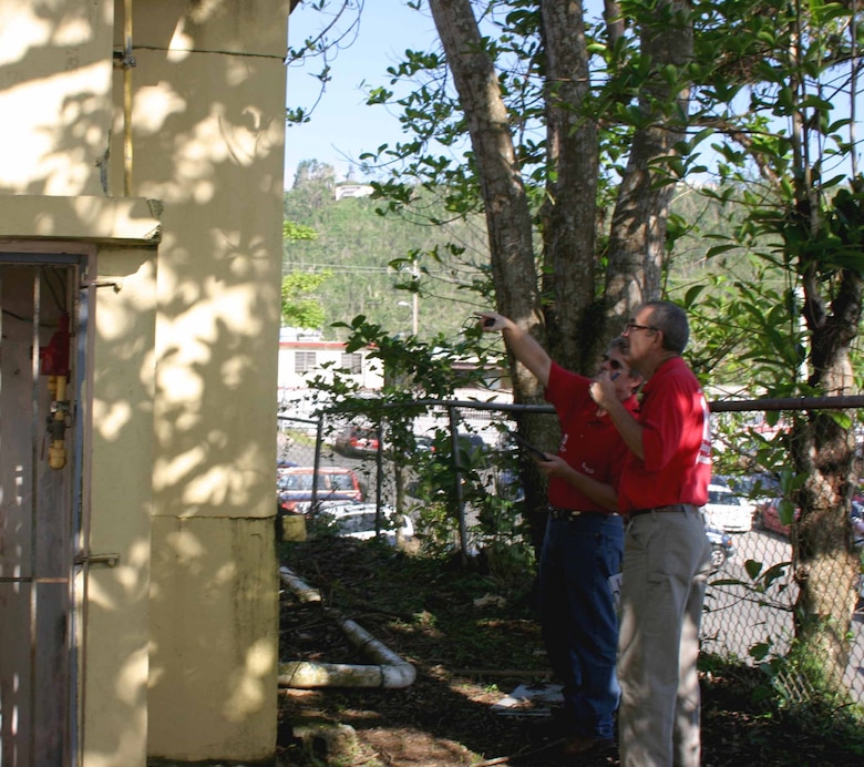 men look at damaged school building