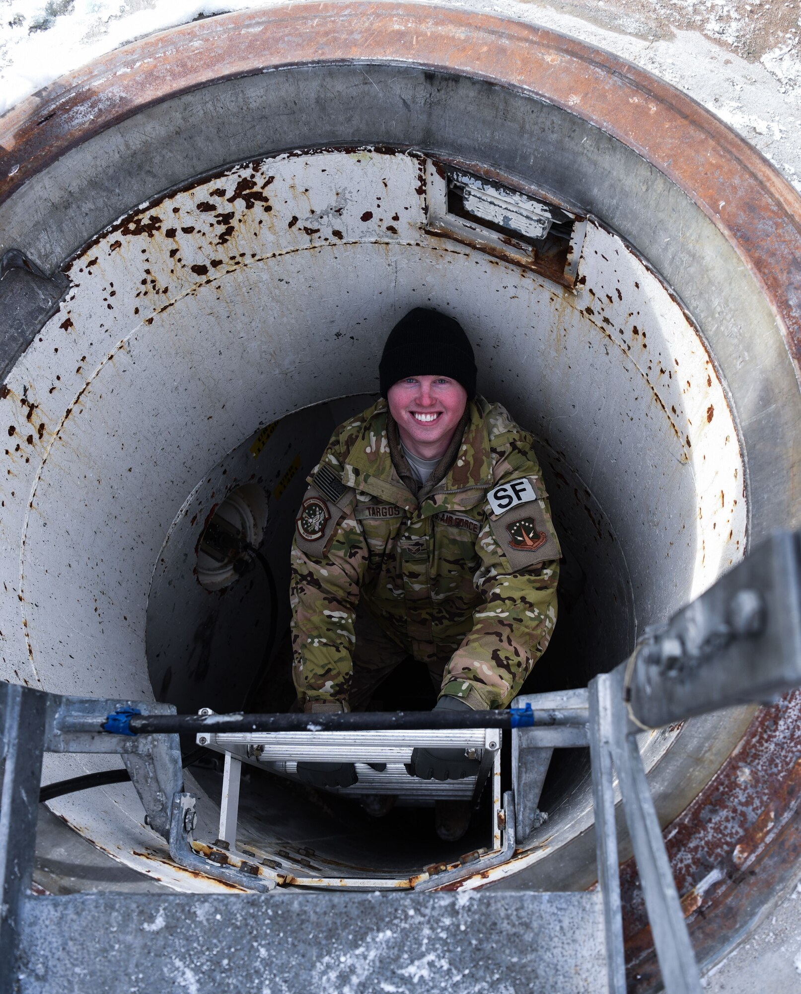 Senior Airman Joseph Targos, 90th Missile Security Forces response force leader, smiles for the camera while descending a ladder in the F.E. Warren Air Force Base missile complex, Dec. 28, 2017. Members of the 90th Missile Security Forces Squadron got the chance to go into a missile launch facility to see what they protect every day.