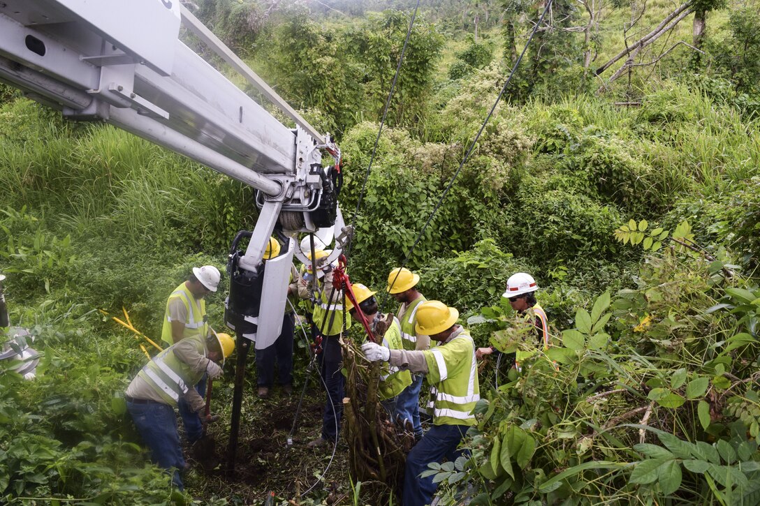 A group of people work around construction equipment.