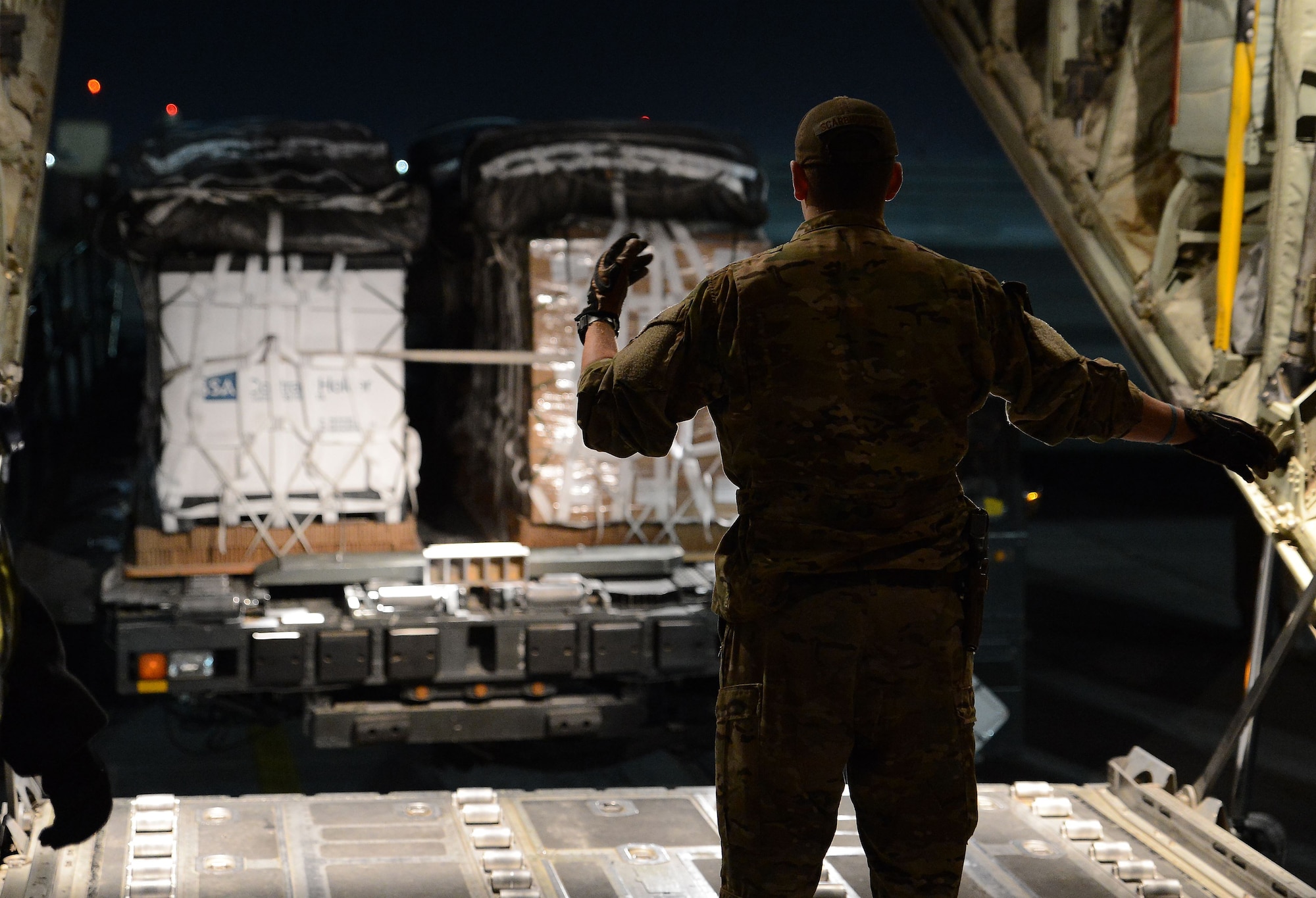 Senior Airman William Scarbrough, 774th Expeditionary Airlift Squadron loadmaster, marshals a forklift onto a C-130J Super Hercules Dec. 13, 2017 at Bagram Airfield, Afghanistan.