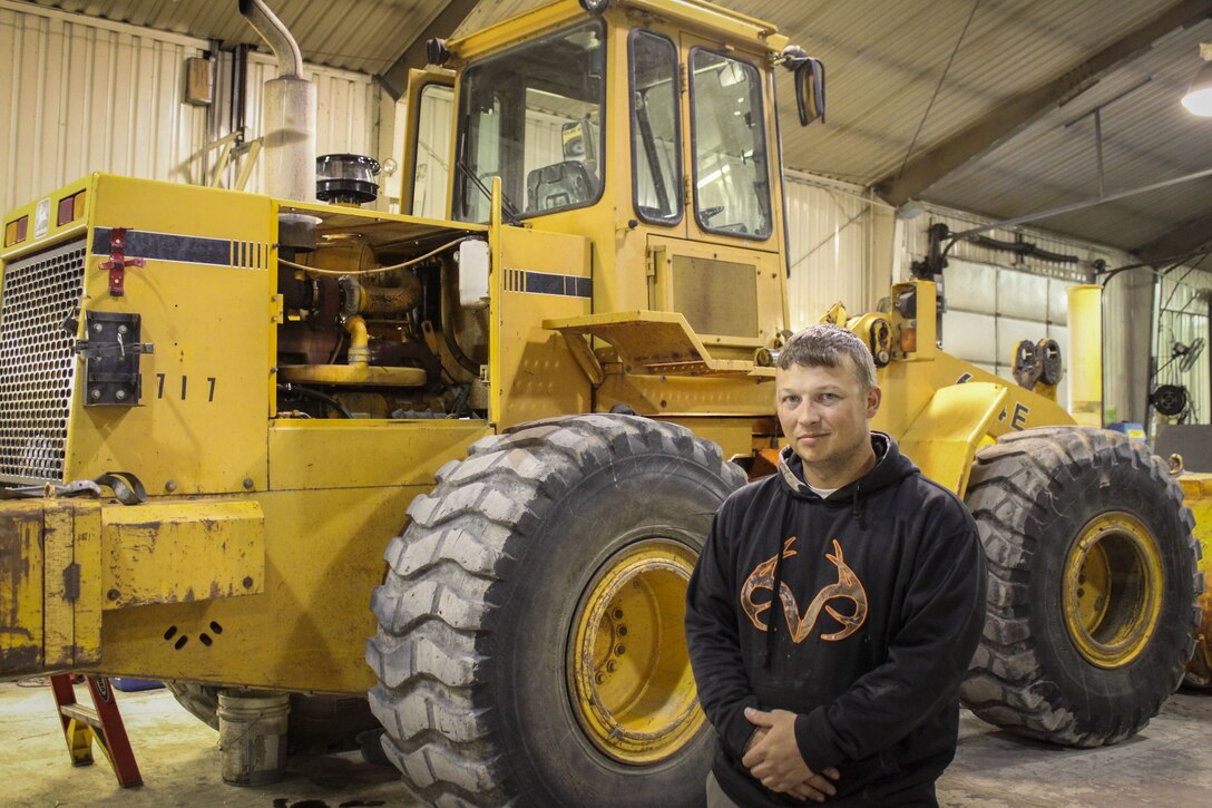 man stands in front of heavy equipment