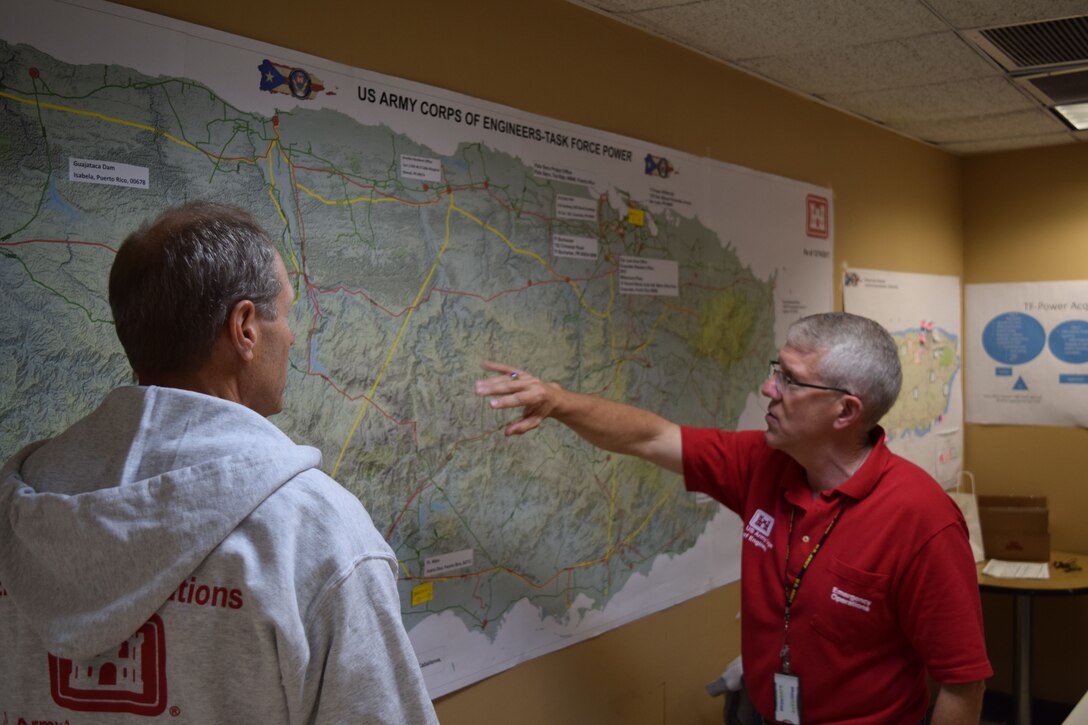 Task Force Power Restoration Program Manager, Philip R. Tilly (right), shows Jay Field, TF Power public affairs, the path the storm took as it made landfall onto Puerto Rico, Sept. 20.