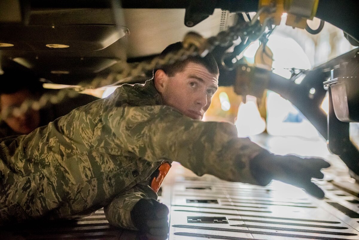 Staff Sgt. Kaleb Wentworth, an aerial port specialist with the Kentucky Air National Guard’s 123rd Logistics Readiness Squadron, chains a Kentucky Army National Guard helicopter to the floor of an aircraft at the Kentucky Air National Guard Base in Louisville, Ky., on January 27, 2017.  Wentworth was selected from among more than 1700 aerial porters as the top transportation journeyman in the Air National Guard for 2016.