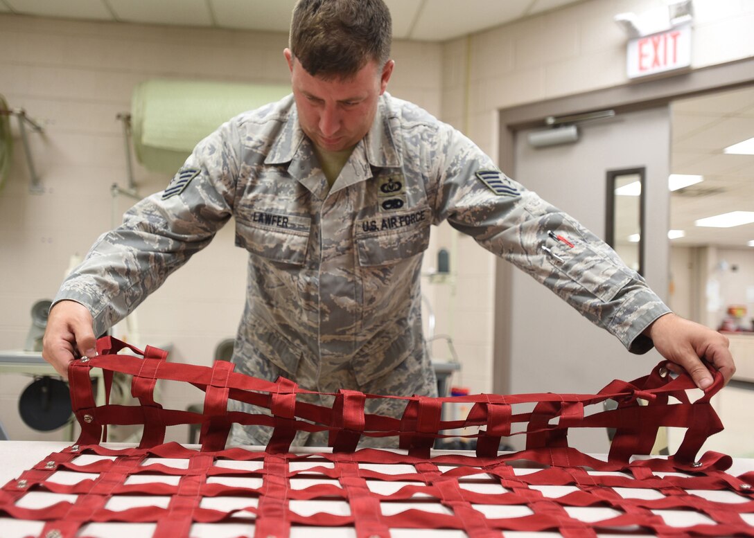 Tech. Sgt. Lawrence Lawfer, an aircrew flight equipment journeyman with the Kentucky Air Guard’s 123rd Operations Support Squadron in Louisville, Ky., inspects and identifies tears and other deficiencies on an aircraft seat harness June 9, 2017. The repair of life-saving equipment is the responsibility of the aircrew flight equipment shop here.