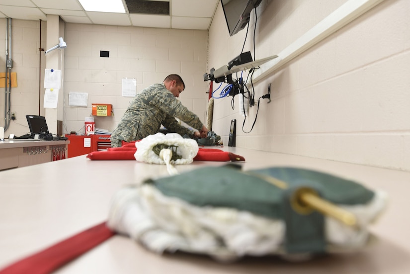 Tech. Sgt. Christopher Brawner, an aircrew flight equipment journeyman with the Kentucky Air Guard’s 123rd Operations Support Squadron in Louisville, Ky., repacks a parachute after performing routine maintenance June 9, 2017. The parachute is just one of the many life-saving devices that are put aboard aircraft by members of the aircrew flight equipment shop after careful inspection