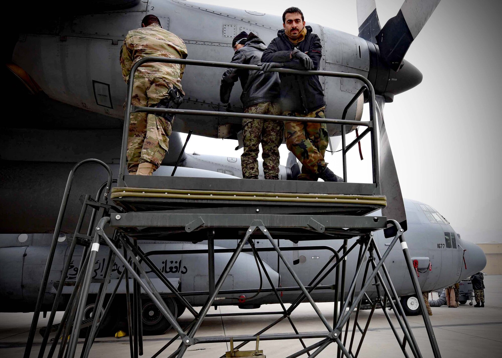 Tech. Sgt. Toron Bordain, 440th Air Expeditionary Advisory Squadron, C-130 maintenance advisor, works with his Afghan Air Force counterparts to remove an engine panel for training at Kabul Air Wing, Afghanistan, Jan. 18, 2017. Bordain, an Air Force Reservist out of Dobbins Air Reserve Base, Ga., is part Train, Advise, Assist Command-Air (TAAC-Air), working to develop a professional, capable and sustainable Afghan Air Force. (U.S. Air Force photo by Tech. Sgt. Veronica Pierce) 