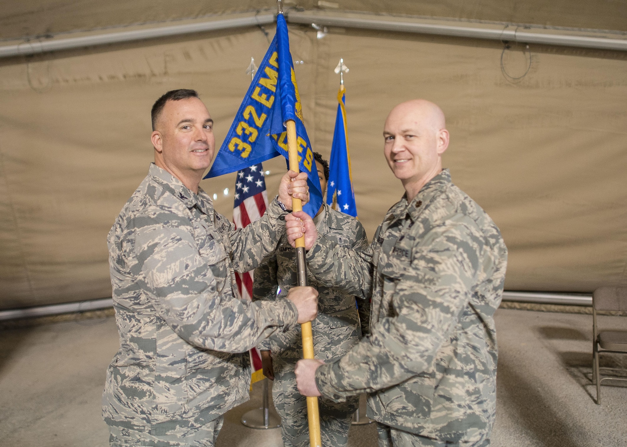 U.S. Air Force Maj. Benjamin Simon, 332nd Expeditionary Civil Engineer Squadron incoming commander, receives command from Col. Daniel Guinan, 332nd Expeditionary Mission Support Group commander, during a change of command ceremony Jan. 13, 2017, at an undisclosed location in Southwest Asia. (U.S. Air Force photo by Staff Sgt. Eboni Reams/Released)